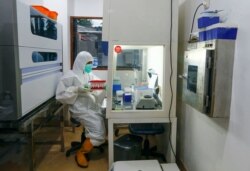 Seorang staf memegang sampel tes PCR di Rumah Sakit Pusat Pertamina di tengah wabah COVID-19 di Jakarta, 16 Desember 2020. (Foto: REUTERS/Ajeng Dinar Ulfiana)