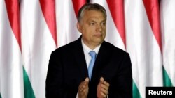 FILE - Hungarian Prime Minister Viktor Orban applauds as he presents the program of his Fidesz party for European Parliament elections in Budapest, Hungary, April 5, 2019.