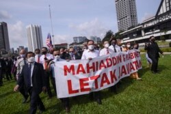 Anggota parlemen oposisi Malaysia Anwar Ibrahim (tengah) dan lainnya berbaris di parlemen saat mereka memprotes penutupannya di Kuala Lumpur pada 2 Agustus 2021. (Foto: AFP/Arif Kartono)