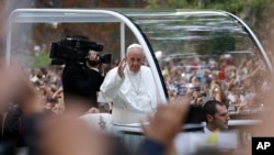 Pope Francis waves to the crowd from his popemobile as it moves through Central Park in New York, Sept. 25, 2015.