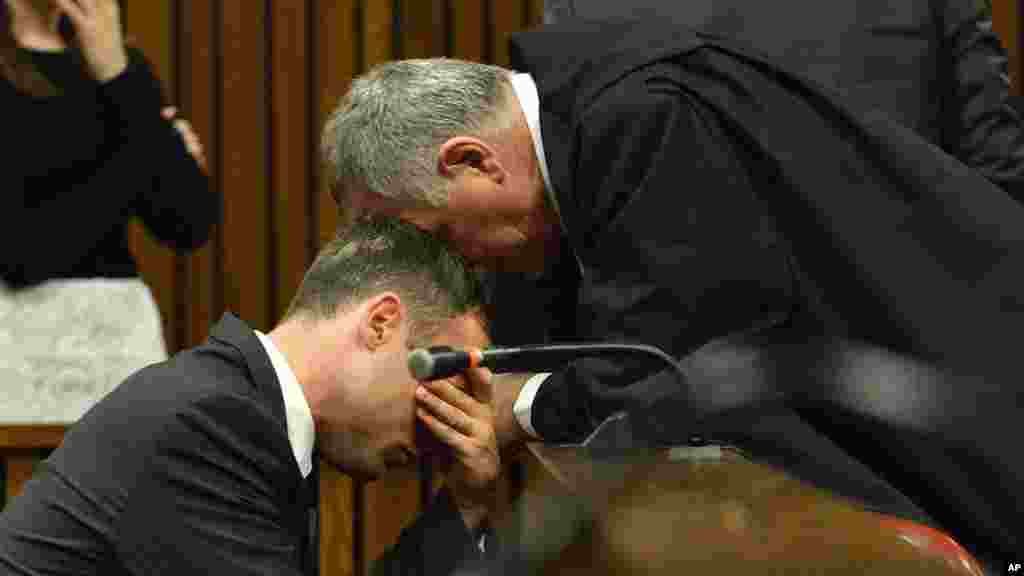 Oscar Pistorius, à gauche, en pleurs, est consolé par son avocat, Barry Roux, lors de la troisième journée d&#39;audiences de détermination de la peine dans la haute cour à Pretoria, Afrique du Sud, le 15 octobre 2014. 