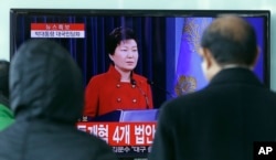 ປະຊາຊົນ ຢືນຊົມການຖ່າຍທອດສົດ ຂອງການກ່າວຖະແຫລງ ທີ່ກອງປະຊຸມຖະແຫລງຂ່າວ ຂອງປະທານາທິບໍດີ ເກົາຫຼີໃຕ້ ທ່ານນາງ Park Geun-hye, ຢູ່ທີ່ສະຖານີລົດໄຟ ໃນນະຄອນຫຼວງໂຊລ ຂອງເກົາຫຼີໃຕ້, ວັນທີ 13 ມັງກອນ 2016.