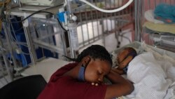 Seorang perempuan beristirahat di dekat anak laki-lakinya yang baru lahir di Rumah Sakit khusus anak-anak di Port-au-Prince, Haiti, pada 24 Oktober 2021. (Foto: AP)