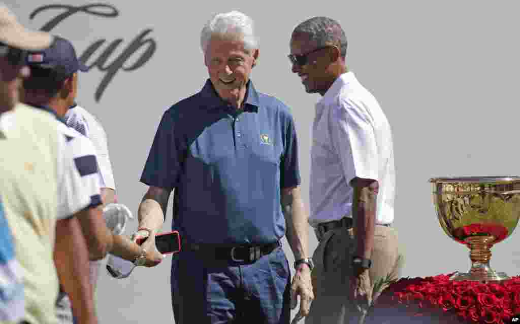 Barack Obama, à droite, et Bill Clinton saluent les membres de l&#39;équipe américaine avant le premier tour de la Coupe des Présidents au Liberty National Golf Club à Jersey City, N.J., 28 septembre 2017.