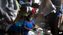 Jessica Vega has drug-resistant tuberculosis. She cooks in her home in the poor neighborhood of Carabayllo in Lima, Peru, Sept. 30, 2015. (AP Photo)