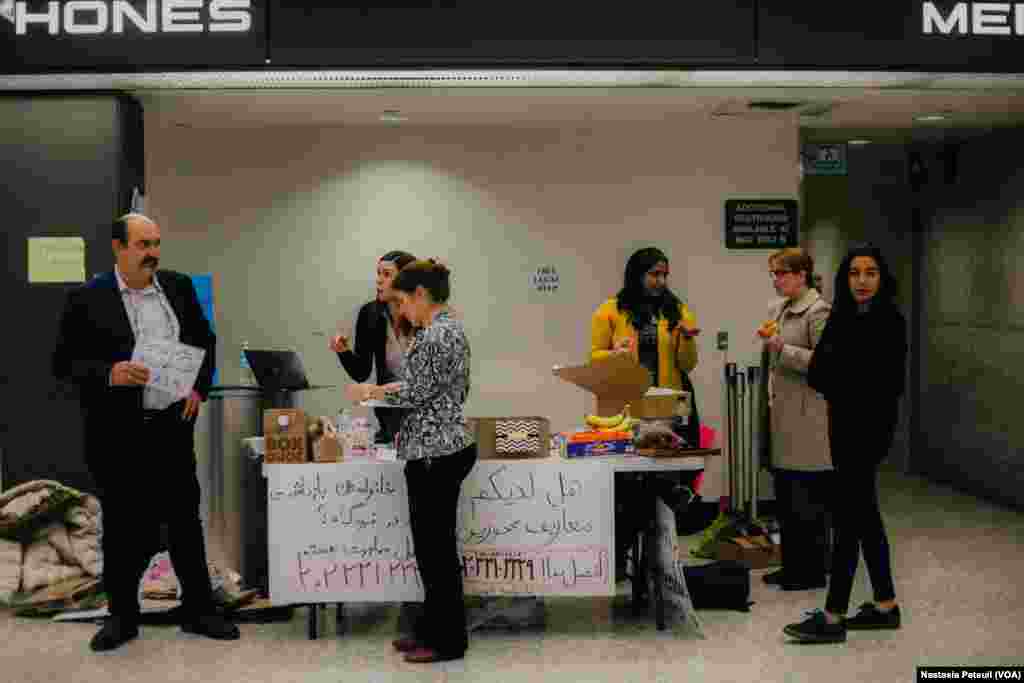 Le groupement d'avocats CairCoalition accueillent les touristes et les résidents à l'aéroport international de Washington DC, le 31 janvier 2017. (VOA/Nastasia Peteuil)