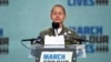 FILE - Emma Gonzalez, a survivor of the mass shooting at Marjory Stoneman Douglas High School in Parkland, Fla., stands silently for the amount of time it took the shooter to go on a killing spree, during a rally in support of gun control in Washington, Mar. 24, 2018.