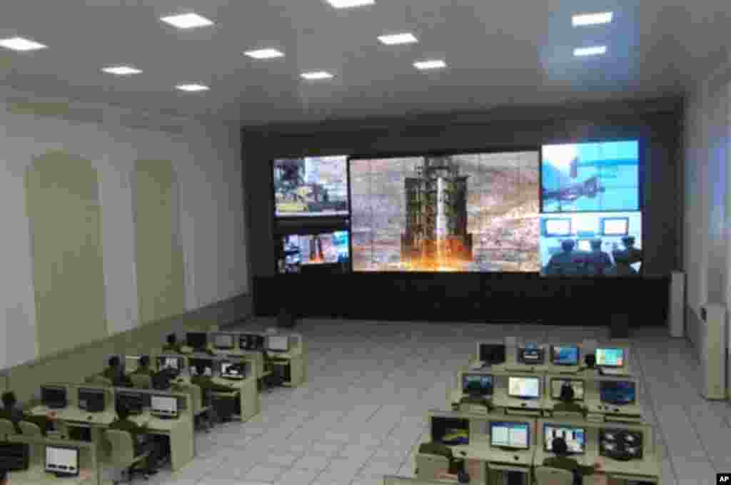 Scientists and technicians at the General Satellite Control and Command Center on the outskirts of Pyongyang watch the launch of the Unha-3 rocket from a launch site on the west coast, in the village of Tongchang-ri, about 56 kilometers (35 miles) from th