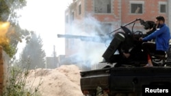 A member of the Libyan internationally recognized government forces fires during a battle with eastern forces in Ain Zara, Tripoli, Libya, April 25, 2019.