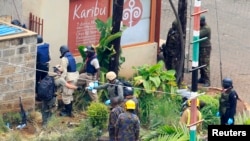 Pakar forensik dari luar Kenya dikawal oleh petugas militer Kenya memeriksa tembok di sekeliling Westgate Mall di Nairobi (25/9).