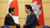 Japanese Prime Minister Shinzo Abe, right, and Cambodia's Prime Minister Hun Sen shake hands after their meeting at Abe's office in Tokyo Monday, Oct. 8, 2018. (AP Photo/Eugene Hoshiko, Pool)