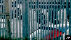 Police officers wear protective suits inside the fence of "Ashley Wood Recovery", a vehicle recovery business in Salisbury, near where the car of Sergei Skripal was taken on March 13, 2018.