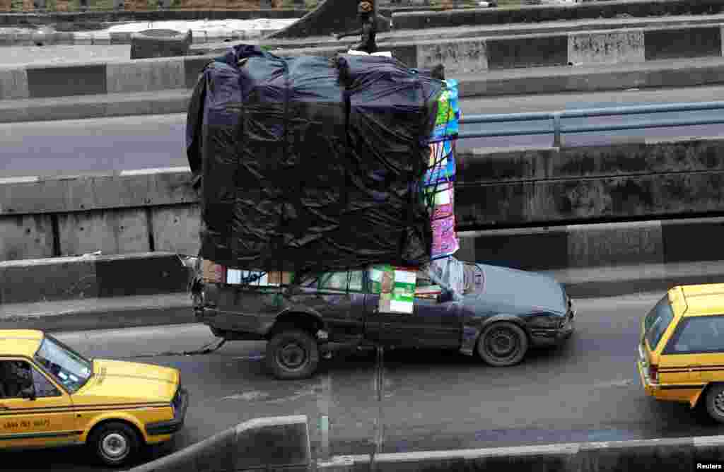 A car, loaded with household wares, drives up a bridge at the Orile-Iganmu district of Lagos.