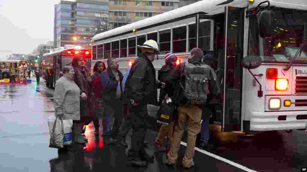 Toussant, les personnes évacuées d&#39;un tunnel de métro de métro enfumé sont embarquées dans un bus à Washington, lundi 12 janvier, 2015. 