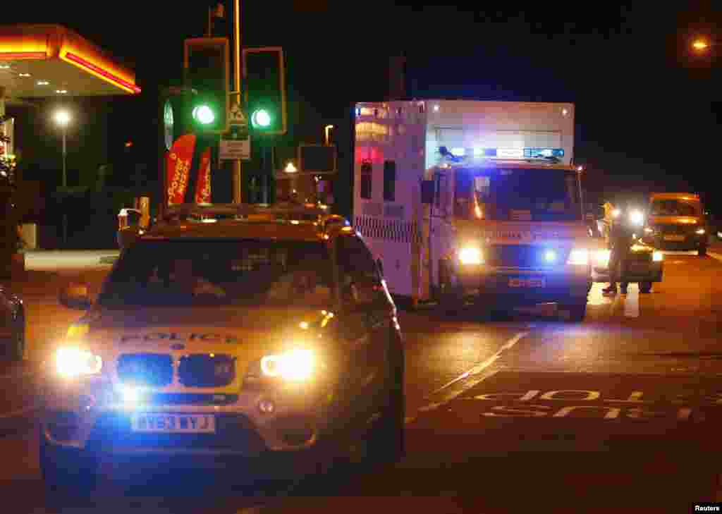 Police escort a military ambulance carrying a British man infected with the Ebola virus after he was flown home on a C17 plane from Sierra Leone, at Northolt air base outside London, Aug. 24, 2014.