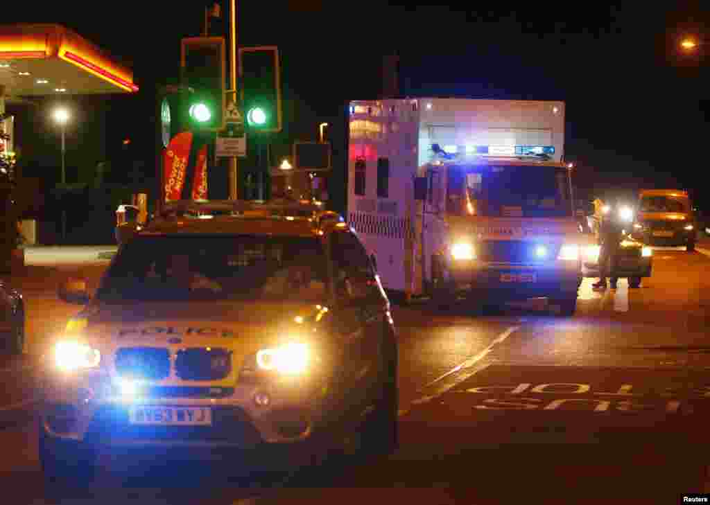 A polícia escolta uma ambulância militar, que leva o homem britânico infectado com o vírus do Ébola, depois de ter voltado da Serra Leoa, Ago. 24, 2014.