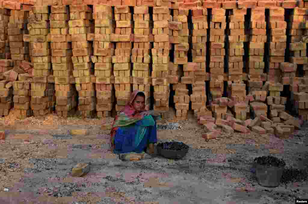 파키스탄 이슬라마바드 외곽의 벽돌 생산공장에서 일하는 어린 소녀가 휴식을 취하고 있다.