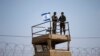 FILE - Israeli soldiers stand guard atop a watch tower along the Israel-Gaza Strip border, May 15, 2018.