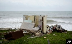 FILE - A completely ruined house is seen in El Negro community a day after the impact of Hurricane Maria, in Puerto Rico, Sept. 21, 2017.