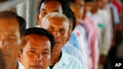 Cambodians line up at a court entrance before a hearing to prepare for the genocide trial of two surviving leaders Khieu Samphan and Noun Chea, at the U.N.-backed war crimes tribunal in Phnom Penh, Cambodia, July 30, 2014. 