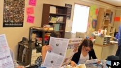 Little Wound journalism class students check their published work.