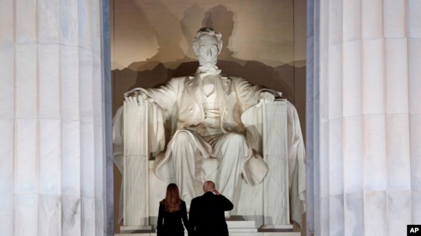 El presidente electo Donald Trump y su esposa, Melania Trump, saludan el monumento del Lincoln Memorial, al llegar la noche anterior a su posesión como presidente de EE.UU., al "Make America Great Again Welcome Concert".