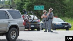 Polisi negara bagian New York menjaga penghalang jalan yang dipasang dekat jalan layang di dekat kota Malone, di tengah pencarian napi buron (27/6). (AFPScott Olson/Getty Images)