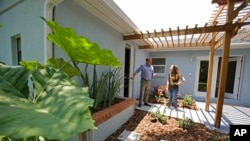 FILE - A real estate agent shows off a home to a prospective buyer in Orlando, Fla., May 23, 2014. In 2018, 40 percent of millennials owned homes — compared to 45 percent of Generation Xers and baby boomers who owned homes around the same age, according to a new report.