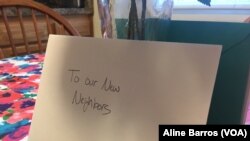 A “Welcome new neighbors” card sits on a kitchen table in a three-story townhouse in Columbia, Maryland. The house is ready for the arrival of a refugee family. (A. Barros/VOA)