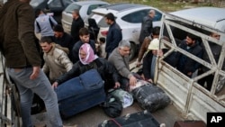 Syrians put their belongings into vehicles after crossing into Turkey at the Cilvegozu border gate with Syria, near Hatay, southeastern Turkey, Dec. 18, 2016.