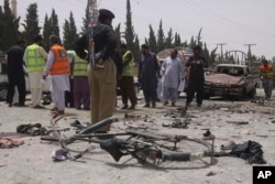 Pakistani security personnel visit the site of bombing in Quetta, Pakistan, July 25, 2018.