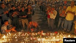Para migran mengadakan penyalaan lilin untuk mengenang tewasnya 71 migran dalam sebuah truk di Austria, dalam acara di Budapest, Hungaria hari Jumat (28/8).