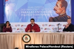 Venezuela's President Nicolas Maduro (C) speaks during a meeting with pro-government governors and mayors, next to Venezuela's National Constitutional Assembly Delcy Rodriguez (L) and Venezuela's Vice President Tareck El Aissami, at Miraflores Palace in C