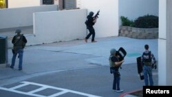 Law enforcement personnel converge on an area near a parking garage adjacent to Building 26 at the Naval Medical Center in San Diego, California, Jan. 26, 2016. 