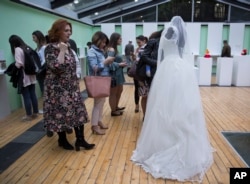 A visitor looks at a wedding dress displayed at the Museum of Broken Relationships in Pristina, Kosovo,May 3, 2018. The dress belongs to a Turkish woman who lost her husband-to-be the day they would get married, June 28, 2016, when a terrorist attack killed him at the Istanbul airport.