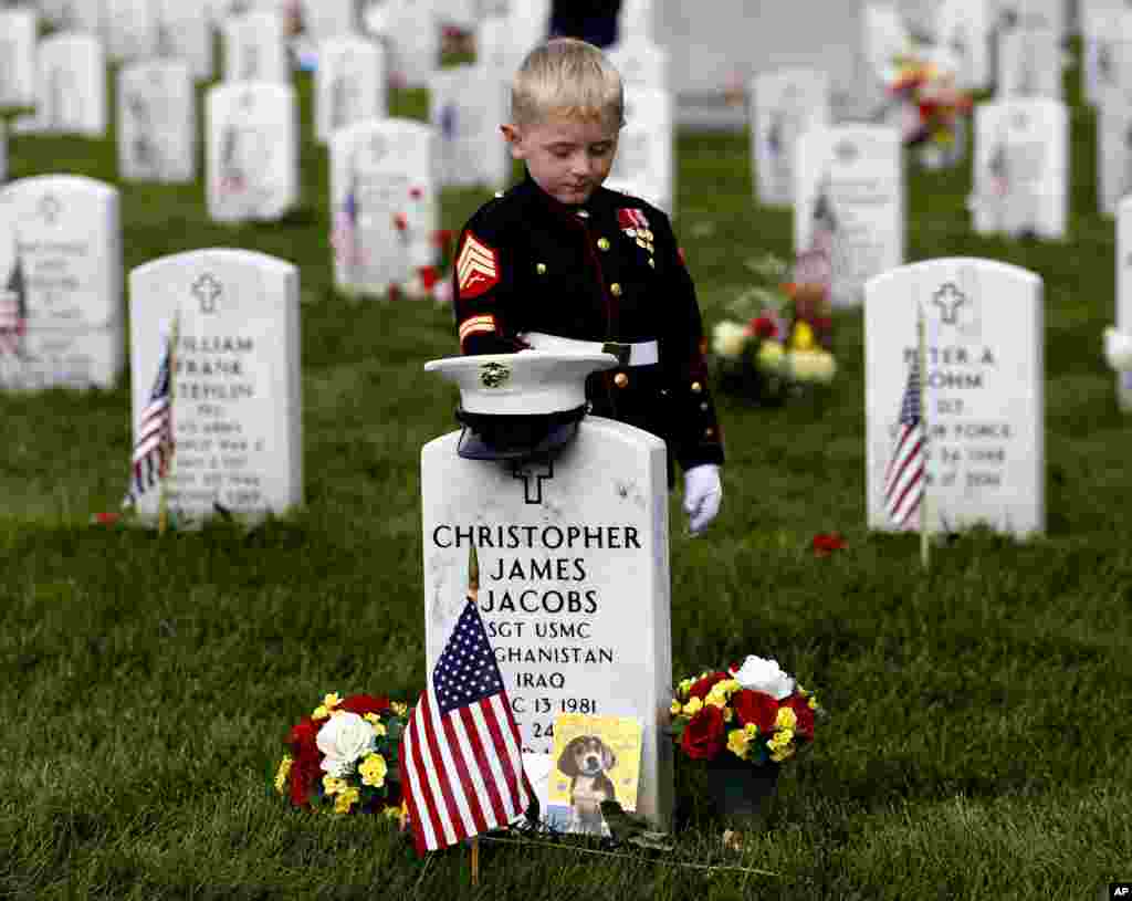 Christian Jacobs, 5, dari Hertford, North Carolina, berpakaian seperti marinir saat mengunjungi makam ayahnya dalam peringatan Memorial Day di Taman Makam Nasional Arlington di Arlington, Virginia (30/5). Ayah Christian, Sersan Marinir Christopher James Jacobs tewas dalam kecelakaan saat pelatihan tahun 2011. (AP/Carolyn Kaster)