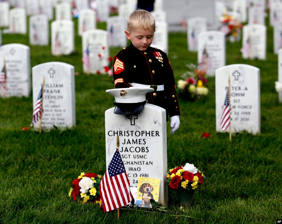 Christian Jacobs, 5, of Hertford, North Carolina, dressed as a Marine, pauses at his father's gravestone on Memorial Day at Arlington National Cemetery in Arlington, Virginia, USA.