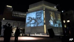 FILE - In this Monday, Nov. 20, 2006, file photo, images from Darfur and Chad are projected on the exterior walls of the United States Holocaust Memorial Museum in Washington.