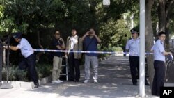 Chinese police officers set up a cordon for journalists outside the gate to the Japanese Embassy ahead of talks between Japan and North Korea in Beijing, August 29, 2012.