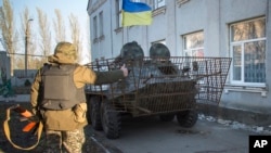 FILE - Ukrainian army soldiers park their APC as they guard a building in Volnovakha, eastern Ukraine, Oct. 26, 2014.