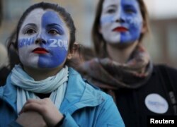 FILE - Natalia Plaza, left, and Suzanne Tufan, with their faces painted, wait for a campaign rally with U.S. Democratic presidential candidate Bernie Sanders in Washington Square Park in the Greenwich Village neighborhood of New York, April 13, 2016.