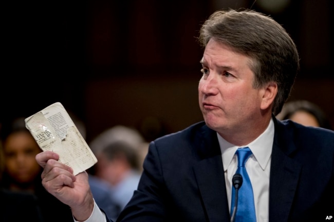 Supreme Court nominee Brett Kavanaugh, a federal appeals court judge, holds up a worn copy of the Constitution of the United States as he testifies before the Senate Judiciary Committee on Capitol Hill in Washington, Sept. 5, 2018.
