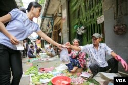 អាជីវករ​មួយរូប​ខ្ចប់​ដោយ​ថង់​ប្លាស្ទិក​ឲ្យ​អតិថិជន​របស់​ខ្លូន​នៅ​ថ្ងៃ​សុក្រ ទី​១៤ ខែ​តុលា ឆ្នាំ​២០១៦ នៅ​ផ្សារ​អូឬស្សី រាជធានី​ភ្នំពេញ។ (ឡេង ឡែន/VOA)