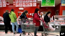 Des consommateurs dans un supermarché à Beijing, le 23 mars 2018. 