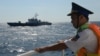 Petugas penjaga wilayah perbatasan Vietnam tampak mengamati kapal patroli perbatasan Vietnam yang berlayar di area dekat kilang minyak China di Laut China Selatan pada 14 Mei 2014. Laut China Selatan menjadi sengketa antara China dan negara-negara Asia Tenggara. (Foto: AFP)
