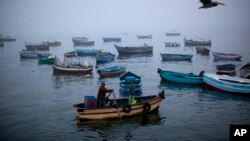 FILE - Fishermen navigate their boat out of the Chorrillo dock in the Pacific Ocean waters of Lima, Peru. Thousands of Chilean fishermen blocked roads with barricades in the region of Los Lagos on Monday and Tuesday.