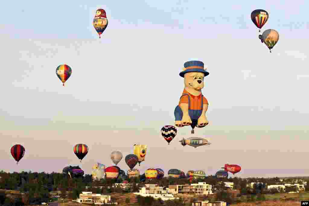 Some of the 100 hot air balloons that participate in the International Hot Air Balloon Festival, fly over Leon, Guanajuato state, Mexico, Nov. 14, 2020.