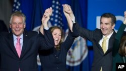 Virginia's governor-elect, Ralph Northam, right, celebrates his election win with Virginia Governor Terry McAuliffe and his wife, Dorothy, in Fairfax, Virginia. Nov. 7, 2017.