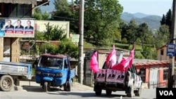 Sebuah kendaraan dengan poster kampanye pemilu lokal berkeliling kota Tirana di Albania, Sabtu (7/5).