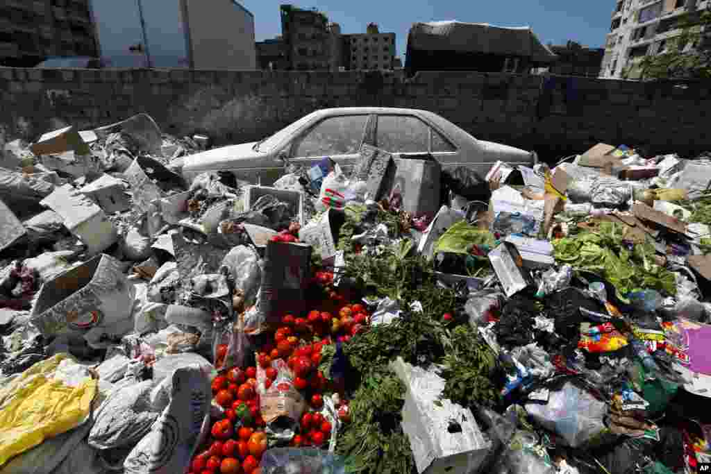 Sebuah mobil terlihat di antara tumpukan sampah yang tertutup pestisida putih di kamp pengungsi Palestina Sabra di Beirut, Lebanon. Kabinet Lebanon gagal mencapai kesepakatan untuk mengatasi krisis sampah negara tersebut yang semakin memburuk, menunda keputusan hingga minggu depan sementara sampah semakin menumpuk di jalan.